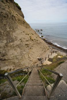 Some wooden steps leading down to a beach from a cliff