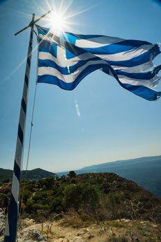 The Greek Flag in Summer on a cliff top