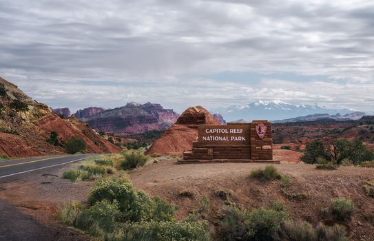 Capitol Reef National Park, Utah, USA - October 20, 2018 : Welcome sign at the entrance to Capitol Reef National park, Utah, with snow covered Rocky Mountains in the background.