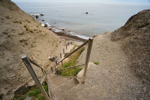 Some wooden steps leading down to a beach from a cliff