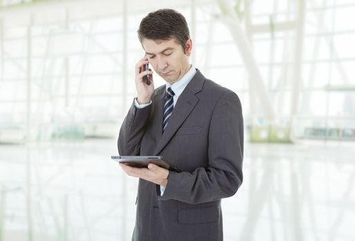 businessman using touch pad of tablet pc, on the phone, at the office