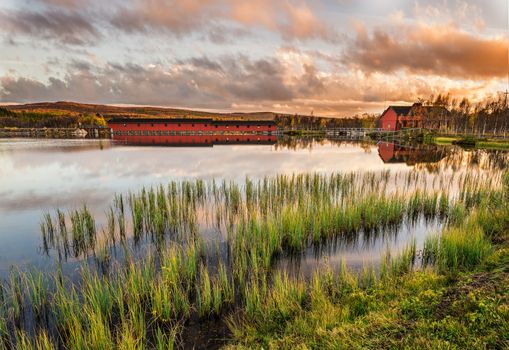 Iconic wooden bridge on Narsjoen lake in Hedmark county, Norway at sunset.