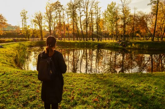 Young woman look at the forest pond