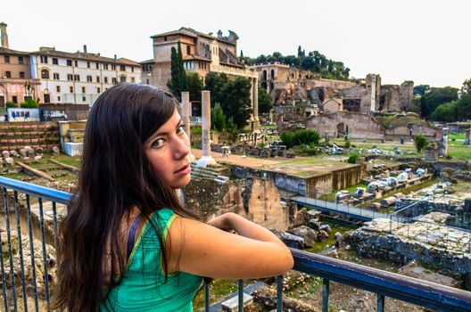 beautiful young girl in a green dress stands near the Roman Forum in Rome, Italy