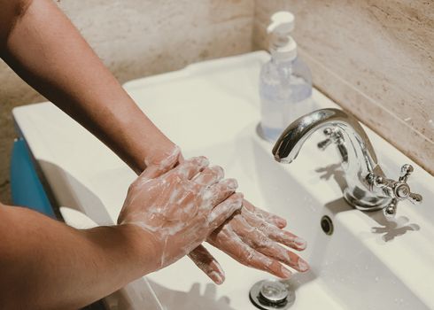 Corona virus travel prevention man showing hand hygiene washing hands with soap in hot water for coronavirus germs spreading protection.