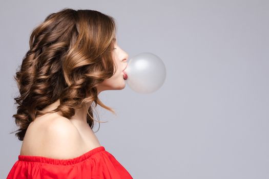 Charming young girl blowing bubble from chewing gum