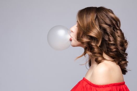 Charming young girl blowing bubble from chewing gum