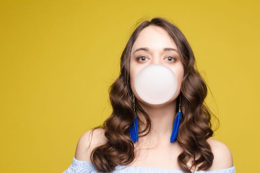 Charming young girl blowing bubble from chewing gum