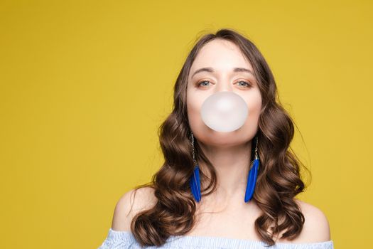 Charming young girl blowing bubble from chewing gum