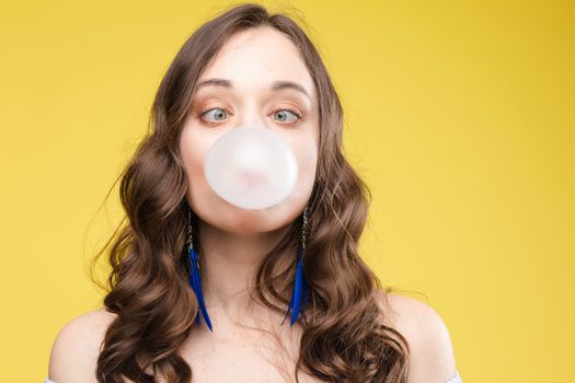 Charming young girl blowing bubble from chewing gum