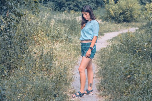 A portrait of a beautiful young caucasian woman with dark hair outdoor.