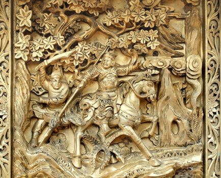 The outside of a large Chinese incense burner shows scenes from Chinese heroic tales
