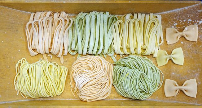 A plate with freshly made pasta in various shapes and colors
