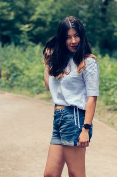 Beautiful young brunette woman against spring street outdoors