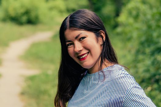 Portrait of a beautiful brunette girl in a spring garden