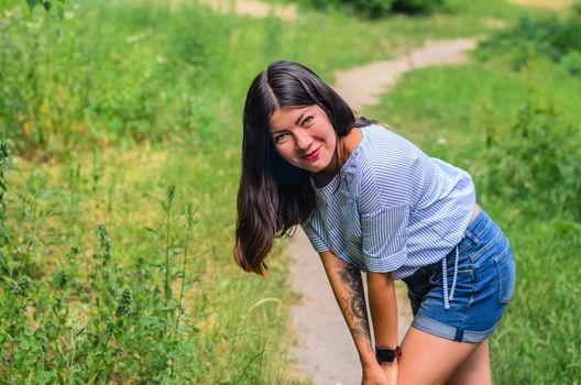 Young and sexy brunette girl with tattoo looking at camera