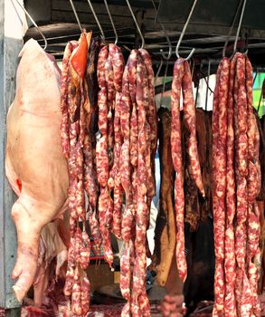 A local butcher street stall with sausages and a side of pork
