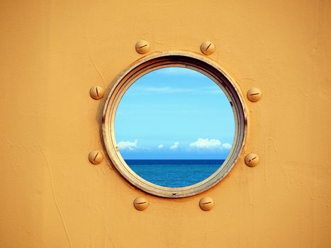Looking through a porthole of a ship one can see the blue ocean and sky.
