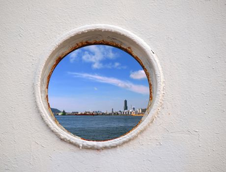 Porthole view of Kaohsiung Harbor on a bright summer day 
