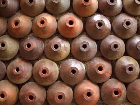 Large earthenware pots are arranged  as a wall design
