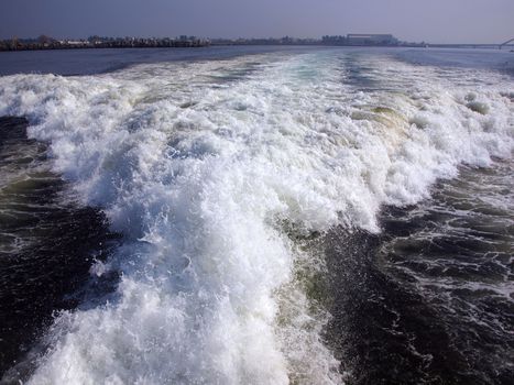 The engines of a powerful speedboat create large wake surfs
