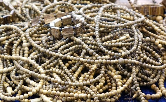 Buddhist prayer beads and bracelets made from wood are sold at an outdoor stall

