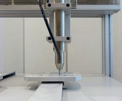A high precision automated drilling tool in operation on a piece of metal