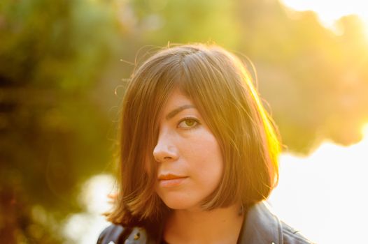 face half covered with black hair of a young white girl in a sunbeam