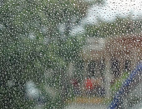 Raindrops form a dense pattern on a window pane
