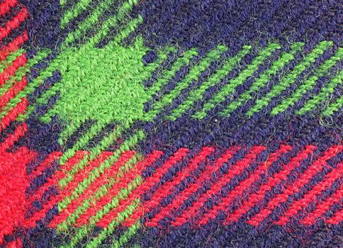 A macro view of a piece of blue cloth with green and red stripes
