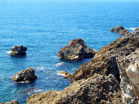 Steep cliffs of coral rock descend into a blue sea
