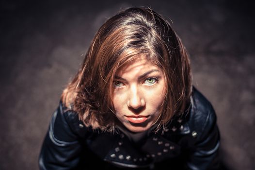 brunette girl in black looks up in the dark