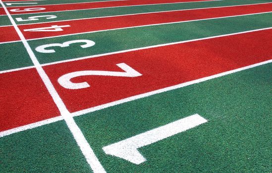 A running track in a stadium with red and green lanes