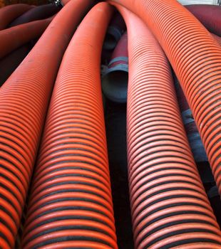 A pile of wide diameter sewage pipes made from corrugated plastic
