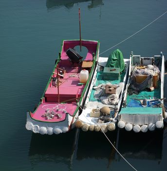 Fishing boats made from hollow tubes are anchored  in the harbor