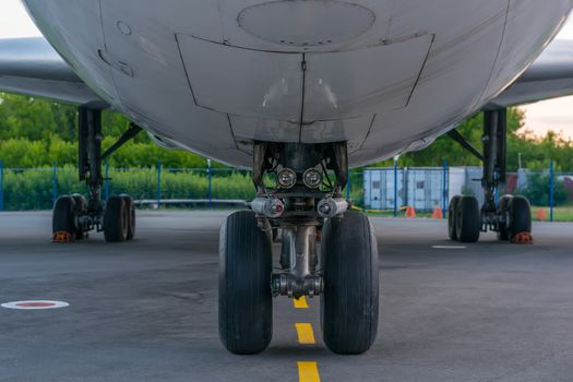 landing gear, wheels and bottom of the aircraft in the Parking lot of the treadmill on the background of the fence and containers