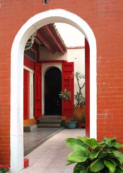 A Chinese temple with a courtyard and red doors
