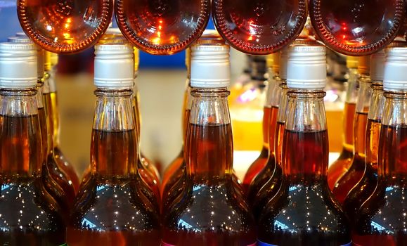 Rows and stacks of glass bottles filled with vinegar

