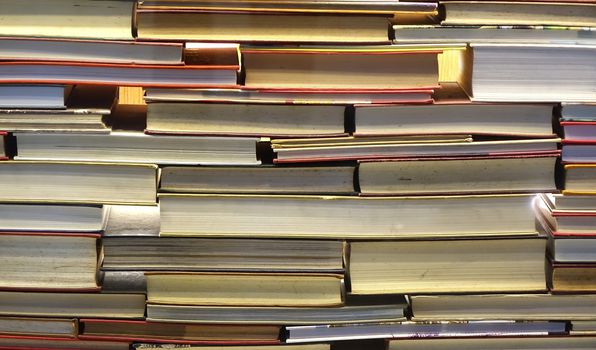 A large pile of old books stacked like a wall