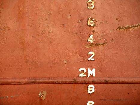 Closeup view of the waterline of a freighter ship anchored in port
