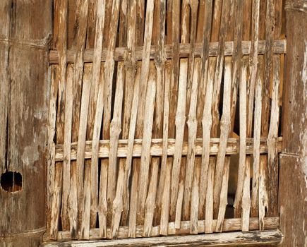 Bamboo slats form a crisscross pattern, an old Chinese farmhouse wall
