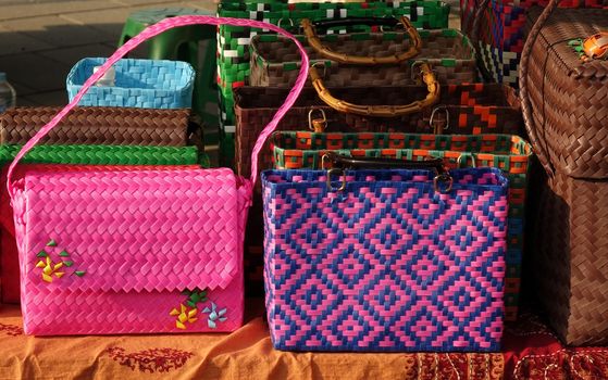 Hand crafted bags for ladies are sold at an outdoor market

