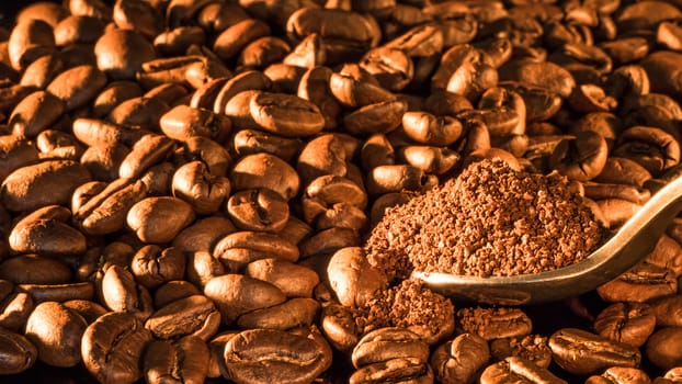 Coffee beans close-up with a spoon of ground coffee.