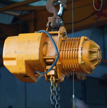 A small yellow winch designed as a gantry crane
