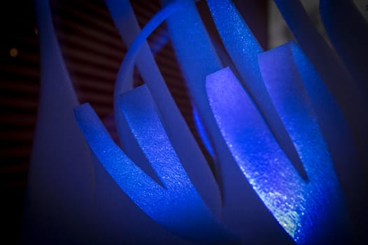 Close-up of blue abstract stripes of foamy material on dark background