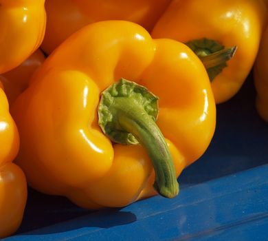 Fresh yellow bell peppers for sale at an outdoor market
