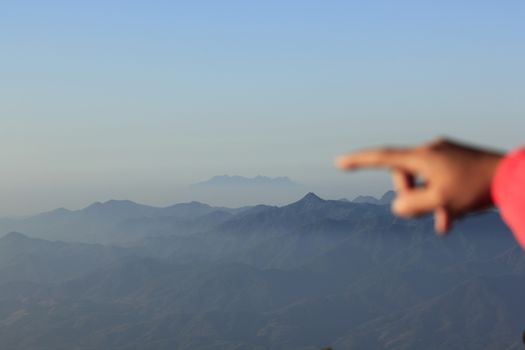 Finger pointing to the mountain.in nature