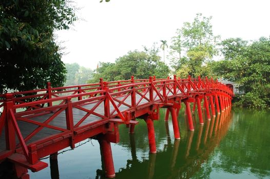 Huc Bridge spanning the Ngoc Son Temple, Hanoi, Vietnam with curved bridge architecture crawfish red symbolizes capital region thousands of years civilization, god temple tortoises enters Vietnam history