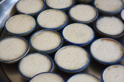 process of making coconut milk custard in small porcelain cup (Thai dessert).