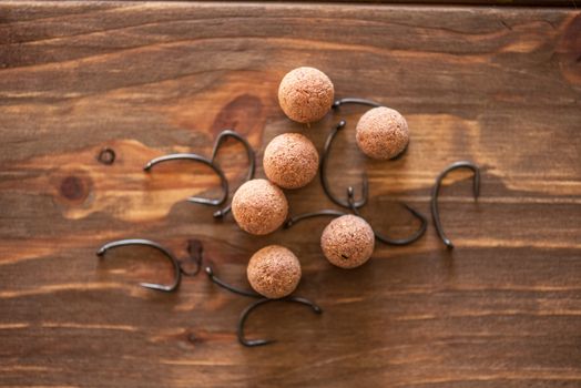 Carp fishing. Different of carp boilies and accessories for carp fishing isolated on wooden background.